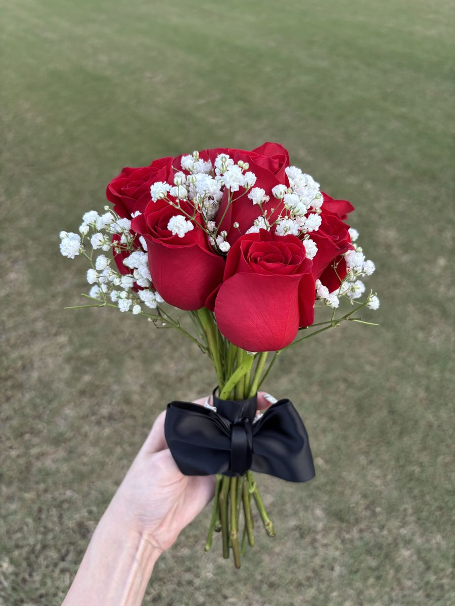 Hand-tied red roses with baby's breath and a black bow